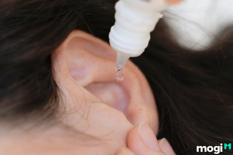 Rửa tai bằng nước ấm để loại bỏ ráy tai, bụi bẩn bên trong tai.